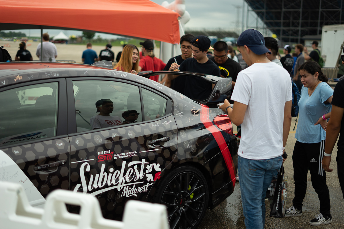Attendees signing the WRX for charity